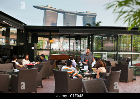 Bevande a Orgo Bar & Ristorante con Marina Bay Sands in background. Il Marina Bay, Singapore Foto Stock