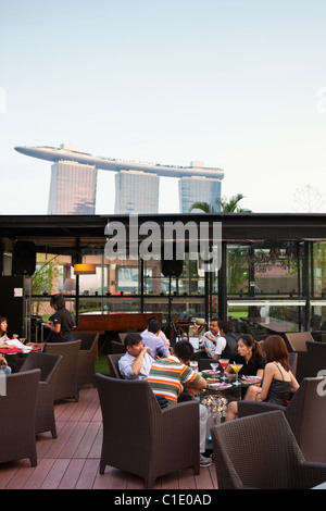 Bevande a Orgo Bar & Ristorante con Marina Bay Sands in background. Il Marina Bay, Singapore Foto Stock