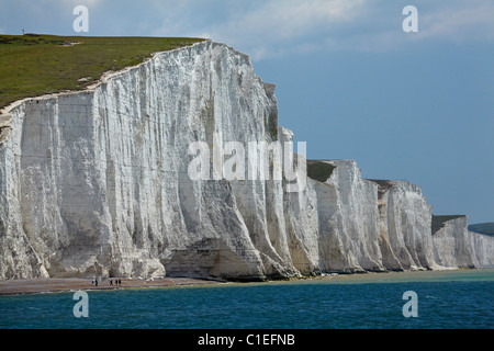 Le persone al di sotto dei sette sorelle Chalk Cliffs, visto da Cuckmere Haven, vicino a Seaford, East Sussex, England, Regno Unito Foto Stock