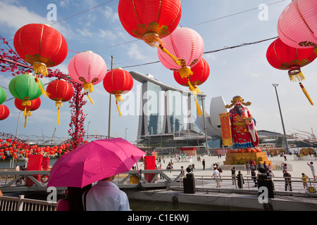 Un giovane si affacciano sul fiume decorazioni Hongbao (Anno Nuovo Cinese) e il Marina Bay Sands Hotel. Il Marina Bay, Singapore Foto Stock