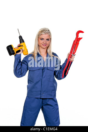 Giovane donna in blu abiti da lavoro con il trapano Foto Stock