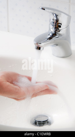 La donna lava le mani sotto acqua corrente e sapone, protezione contro la nuova influenza infezione. Foto Stock