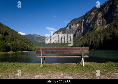Svuotare panca in legno su dge del Lac de Montriond nelle Alpi francesi Foto Stock