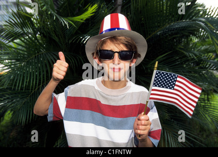 Un ragazzo patriottica in uno zio Sam hat sventola la bandiera americana durante un giorno di indipendenza (4 Luglio) parata di vacanza in Florida, Stati Uniti d'America. Foto Stock