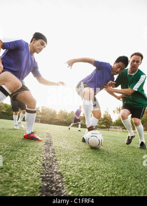 Gli uomini giocano a calcio sul campo di calcio Foto Stock