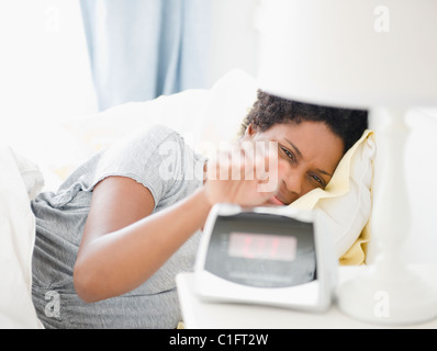 Nero donna disattivazione allarme di mattina Foto Stock