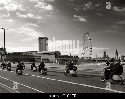 Vespa e Lambrettas giro attraverso il ponte di Waterloo con il London Eye in background Foto Stock