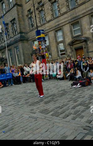 EDIMBURGO - AGO. 9: La folla guarda giocolieri giocolieri che giocolano battoni di fuoco durante l'Edinburgh Festival Fringe godendo buskers artisti di strada. Foto Stock