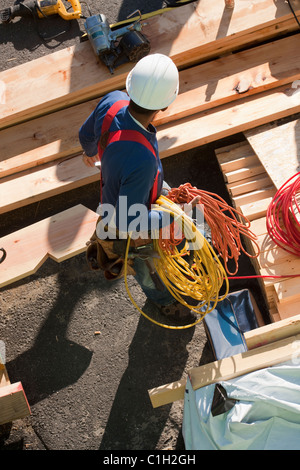 Carpenter spiralato di contenimento dei cavi di alimentazione e il flessibile aria Foto Stock