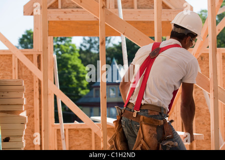 Carpenter portante un puntone di legno Foto Stock