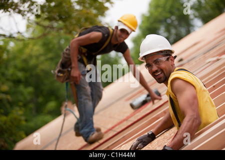 Carpentieri di lavoro sul tetto di una casa in costruzione Foto Stock