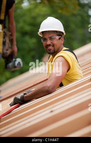 Falegnami ispanica ponendo il pannello del tetto in corrispondenza di una casa in costruzione Foto Stock