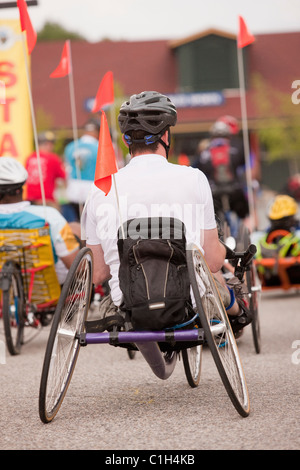 Uomo con lesioni del midollo spinale che partecipano a una gara di triciclo Foto Stock