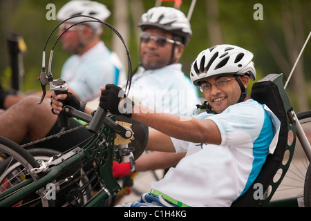 Disabili uomini che partecipano a una gara di triciclo Foto Stock