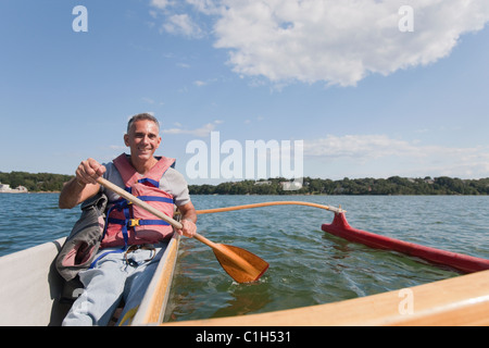 Uomo con lesioni del midollo spinale outrigger canoa in mare Foto Stock