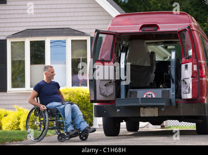 Uomo con lesioni al midollo spinale in una sedia a rotelle arrivare nel suo accessibile van Foto Stock