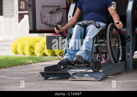 Uomo con lesioni al midollo spinale in una sedia a rotelle arrivare nel suo accessibile van Foto Stock