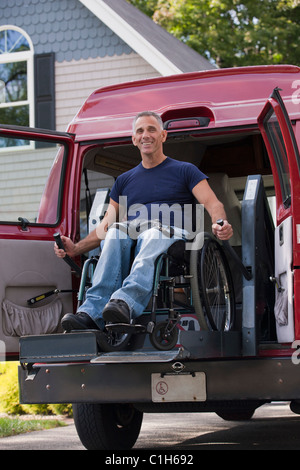 Uomo con lesioni al midollo spinale in una sedia a rotelle arrivare nel suo accessibile van Foto Stock