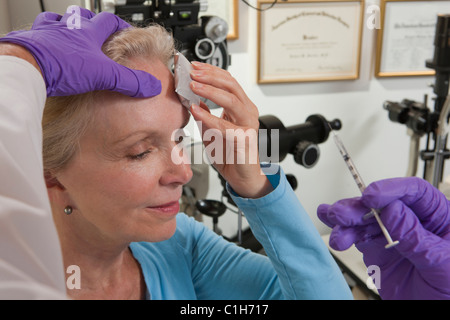 Oculista dando una iniezione di Botox per un paziente Foto Stock