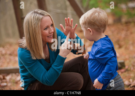 Donna firma la parola "anta" in American Sign Language durante la comunicazione con il figlio Foto Stock