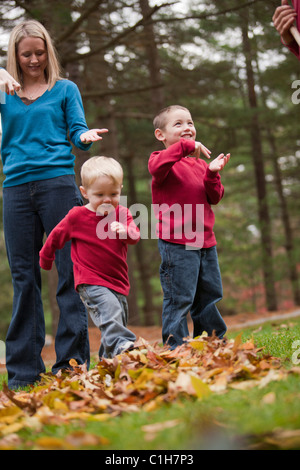 Donna firma la parola "saltare" in American Sign Language durante la comunicazione con i suoi figli in un parco Foto Stock