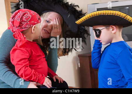 Donna che utilizza American Sign Language per comunicare con i suoi figli vestiti come pirati di Halloween Foto Stock