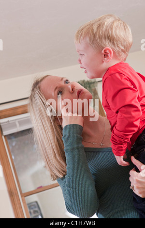 Donna firma la parola "grido" in American Sign Language durante la comunicazione con il suo pianto figlio Foto Stock