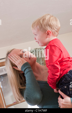 Donna firma la parola "Letto" in American Sign Language durante la comunicazione con il suo pianto figlio Foto Stock