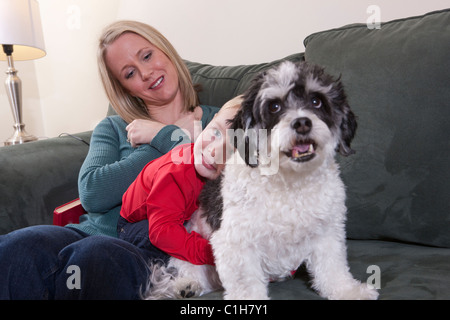 Donna firma la parola "amore" in American Sign Language mentre suo figlio abbraccia un cane Foto Stock