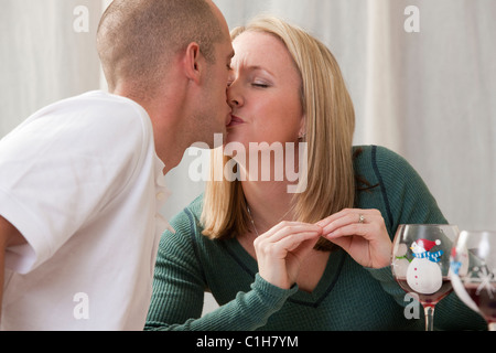 Donna firma la parola "kiss" in American Sign Language mentre baciare il marito Foto Stock