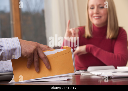 Donna e uomo firma la parola 'Casa' in American Sign Language Foto Stock