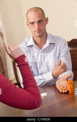 Donna firma la parola 'Drug' in American Sign Language durante la comunicazione con un uomo Foto Stock