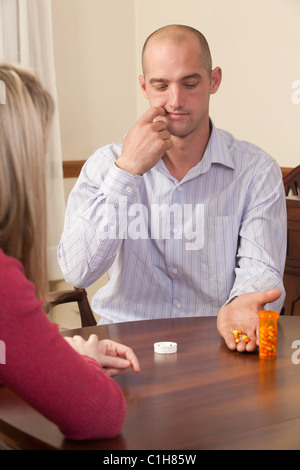 L'uomo firma la parola "Addiction/Addicted' in American Sign Language durante la comunicazione con una donna Foto Stock