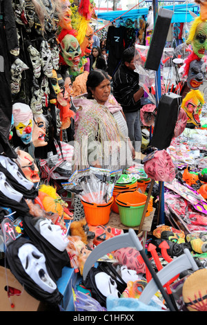 Donna Aymara che vende maschere (tra cui maschere Ghostface dai film di Scream), costumi e articoli per Halloween al mercato di strada, la Paz, Bolivia Foto Stock