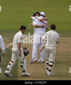 Andrew Strauss e Andrew Flintoff abbraccio dopo la vittoria come Mitchell Johnson e Ben Hilfenhaus lasciare il campo Foto Stock