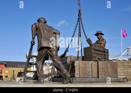 Omaggio storico scultura statua dockers lavorando fuori centro espositivo Excel London Docklands intitolato sbarcati dallo scultore Les Johnson Newham Regno Unito Foto Stock