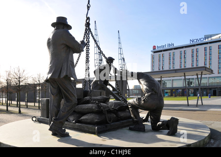 Tributo storico scultura ormeggiatori statua al lavoro fuori del Novotel Hotel Ibis a Londra Docklands intitolato sbarcato dallo scultore Les Johnson Newham UK Foto Stock