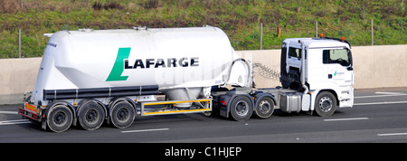 Vista laterale Lafarge porta polvere di cemento sfuso in autocisterna articolata trainata da autocarro hgv bianco che guida lungo l'autostrada M25 Essex Inghilterra UK Foto Stock