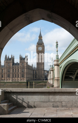 Big Ben clock tower vista lungo il fiume Tamigi, attraverso un arco di Westminster Bridge. Londra. Foto Stock