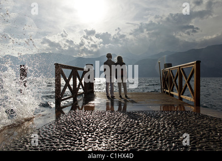 Coppia senior al tramonto guardando su acqua, Italia Foto Stock