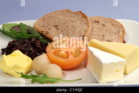 Plowmans il pranzo è servito con il granaio di fresca pane e una selezione di formaggi, pomodoro fresco, decapare la cipolla e chutney di salamoia Foto Stock