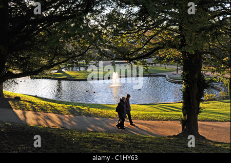 Giovane oltrepassando la fontana in Pavilion Gardens nel Derbyshire Peak District città di Buxton UK Foto Stock