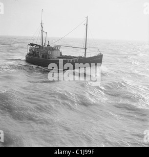 Anni '1950, storico, una fotografia di J Allan Cash di un peschereccio in mare che torna al porto, Inghilterra, Regno Unito. Foto Stock