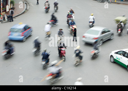 Una donna sola è circondato da moto su una strada trafficata in Hanoi, Vietnam (questo non è stata foto-shopped!) Foto Stock