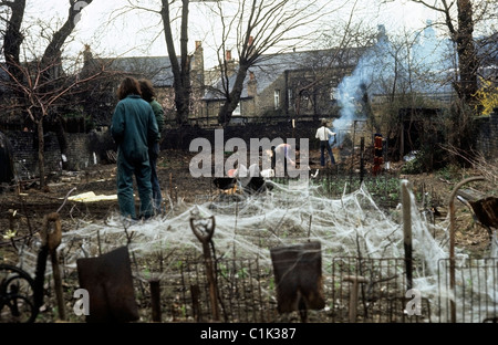 La gente che lavora la cancellazione di un complotto abbandonati a Camberwell che viene cancellato e si è trasformato in un giardino comunale per la coltivazione di ortaggi in Sud Londra Inghilterra degli anni settanta 1976 KATHY DEWITT Foto Stock