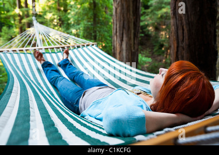 Donna in amaca in alberi di sequoia, Santa Cruz County, California, Stati Uniti d'America Foto Stock