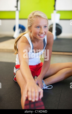 Adolescente Stretching in palestra, Lake Oswego, Oregon, Stati Uniti d'America Foto Stock