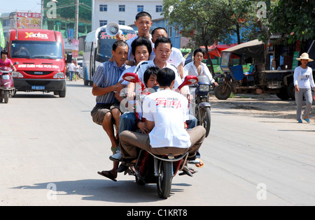 Tutti a bordo! La famiglia che le moto insieme... non ha bisogno di auto! Alcuni genitori farà tutto il possibile per risparmiare un po' di spiccioli - come questo Foto Stock