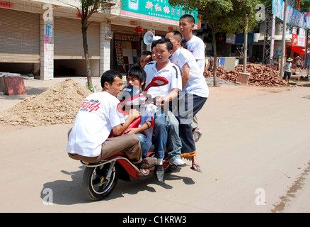 Tutti a bordo! La famiglia che le moto insieme... non ha bisogno di auto! Alcuni genitori farà tutto il possibile per risparmiare un po' di spiccioli - come questo Foto Stock