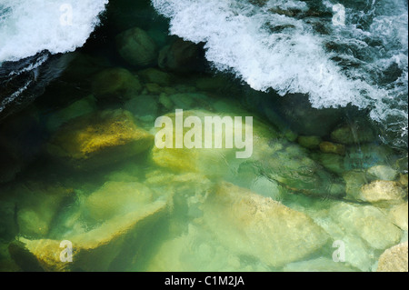 Piccole onde di rottura della schiuma sulla parte poco profonda del fiume. Foto Stock